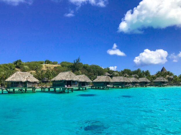 a beach with a bunch of huts in the water